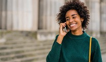 Woman smiling while talking on phone outside