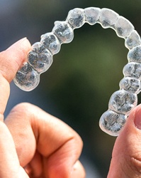 Closeup of hand holding an Invisalign aligner