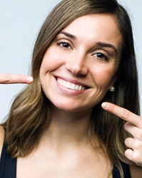 Woman pointing to her beautiful smile