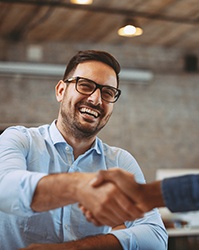 Smiling patient and dentist discussing the cost of dental implants in Boston