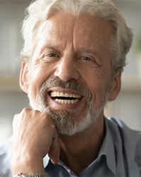 An elderly man with a candid and wide smile