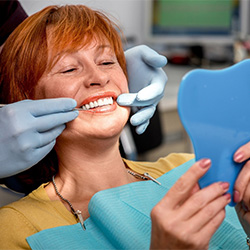 A dentist showing dentures to a senior patient