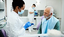 Dentist showing model teeth to patient
