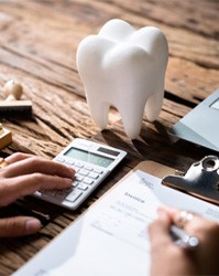 Tooth on table while filling out invoice for insurance