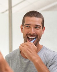 Man brushing teeth to avoid dental emergency in Boston, MA