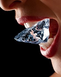 Woman holding an ice cube between her teeth