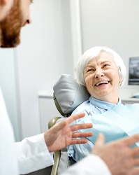 Older woman discussing implant process with dentist
