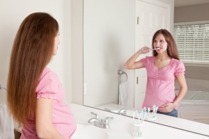 pregnant woman brushing her teeth to avoid periodontal diseasepregnant woman brushing her teeth to avoid periodontal disease