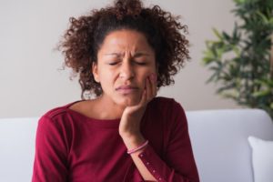 Woman rubbing her jaw due to her mouth pain