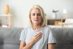 Woman with hand over her heart looking concerned
