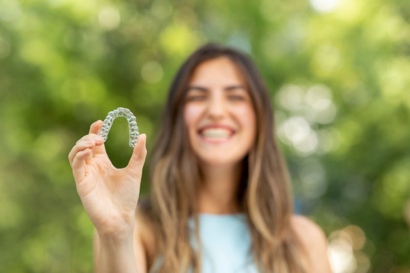 Woman holding an Invisalign aligner