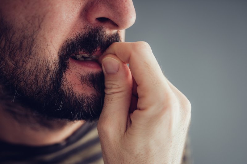 Concerned man chewing on fingernail