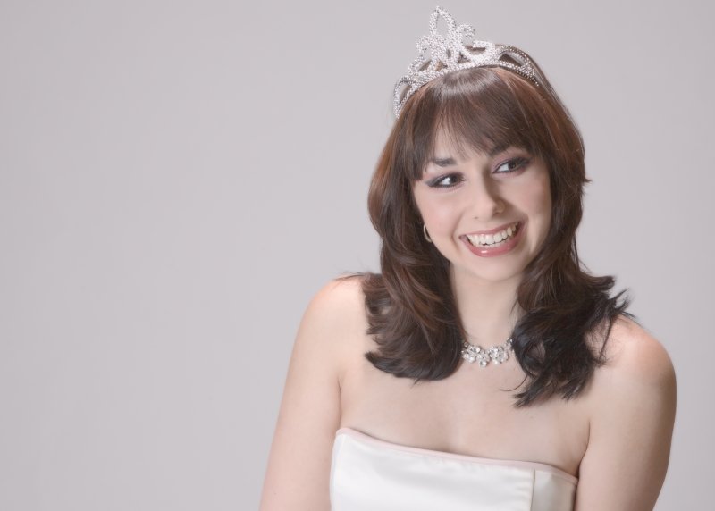 Woman smiles wearing crown.