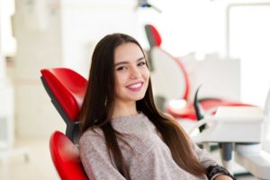 Woman with brown hair smiling sitting in dentists chair
